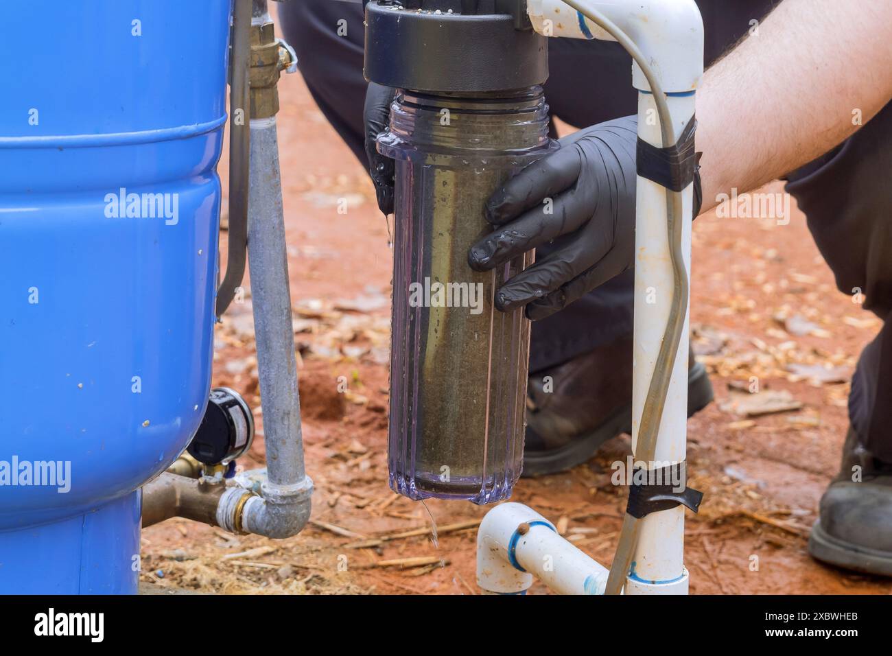 Il lavoratore esegue la manutenzione del filtro di linea dell'acqua residenziale negli impianti di trattamento delle acque domestiche Foto Stock