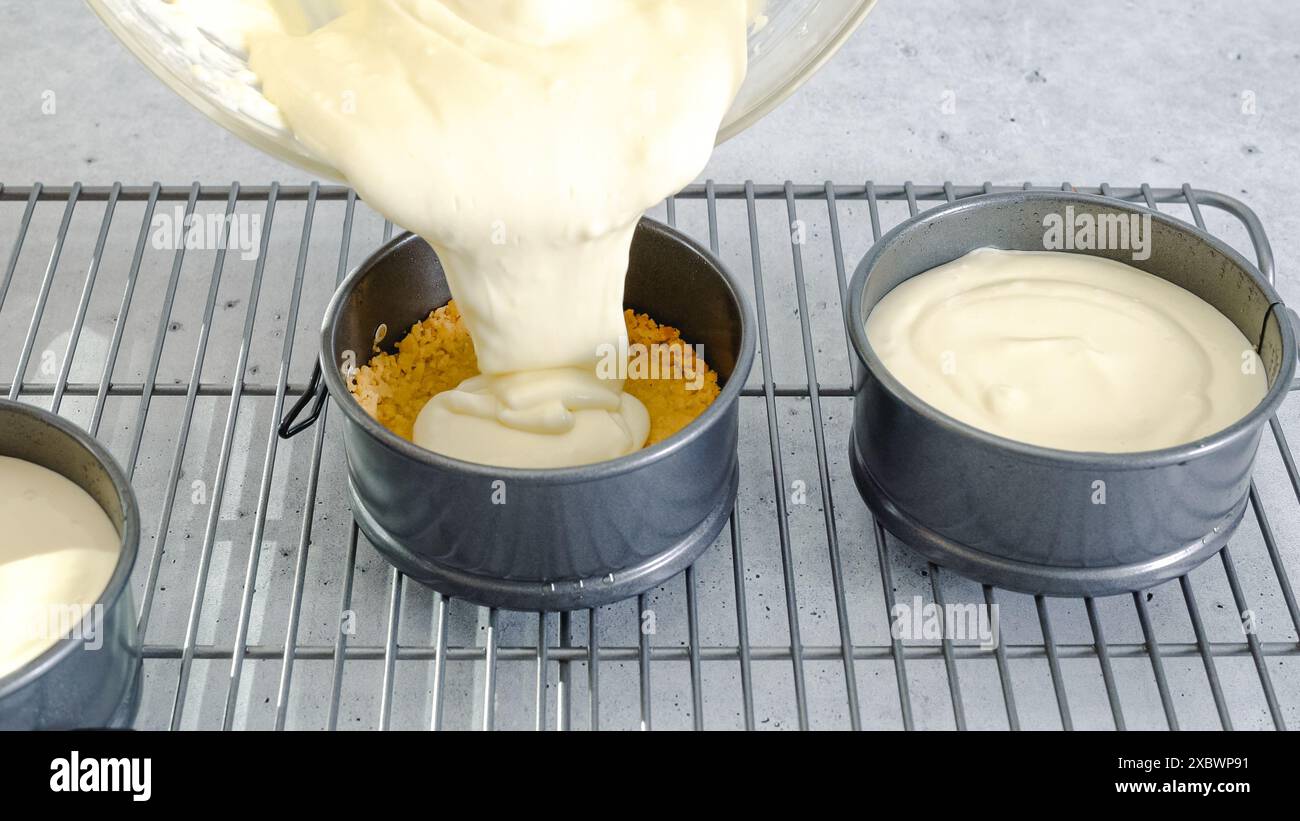 Ricetta per la mini cheesecake. Versare l'impasto per cheesecake in una teglia da forno preparata e procedere di preparazione in primo piano Foto Stock