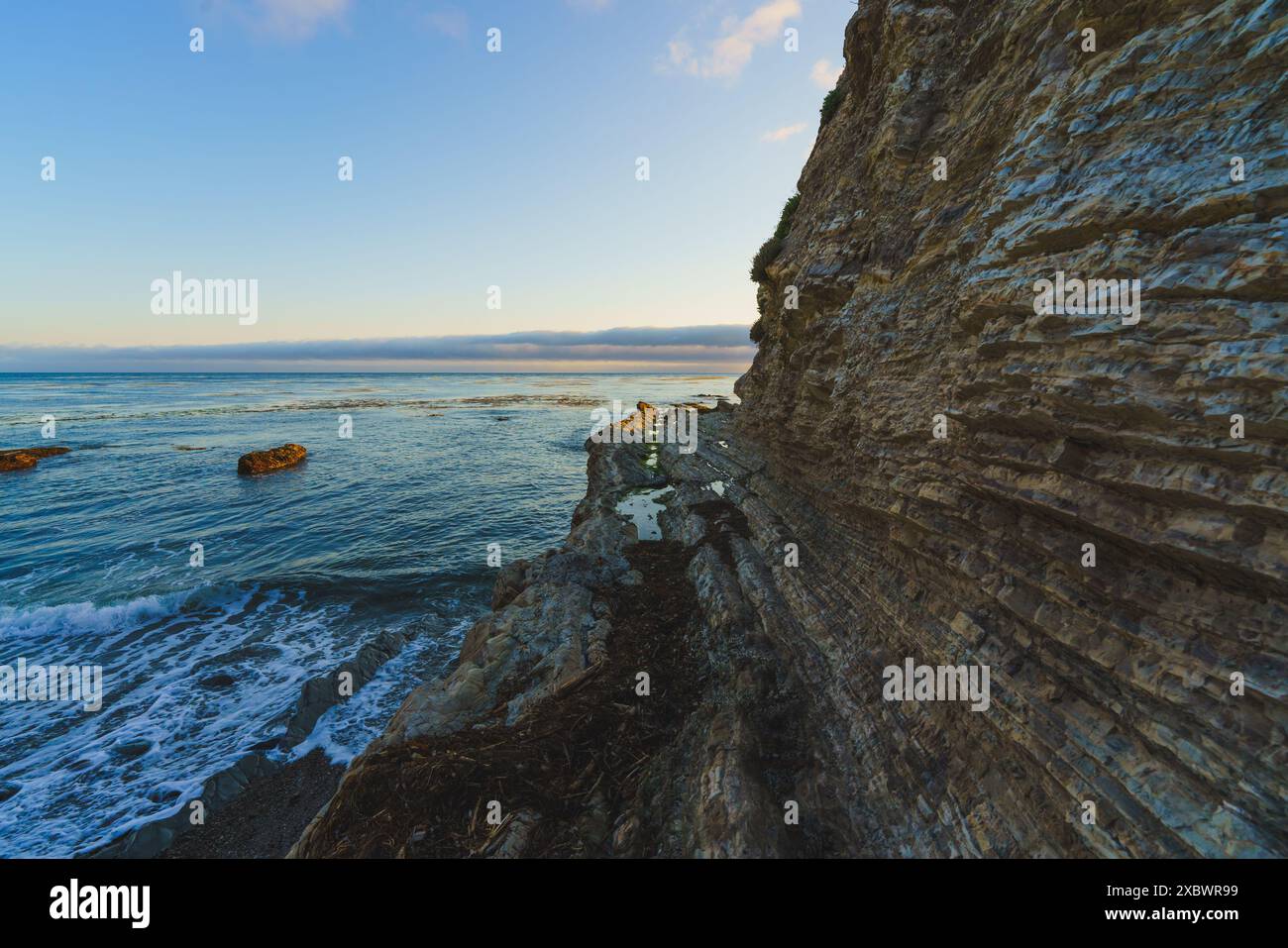 Il mare è bellissimo. Mare blu e scogliere rocciose sulla spiaggia con cielo nuvoloso sullo sfondo Foto Stock