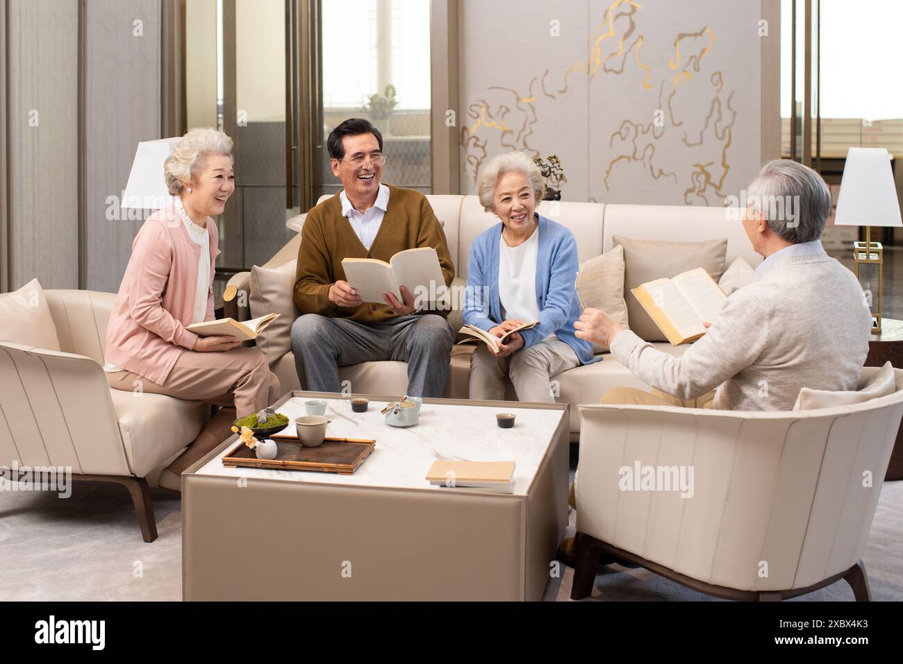 Amici anziani che leggono e discutono libri Foto Stock