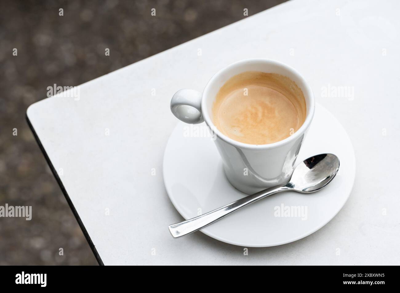 Tazza di caffè e un cucchiaio, un tavolo bianco con tabellone rigido, Jette, Belgio Foto Stock