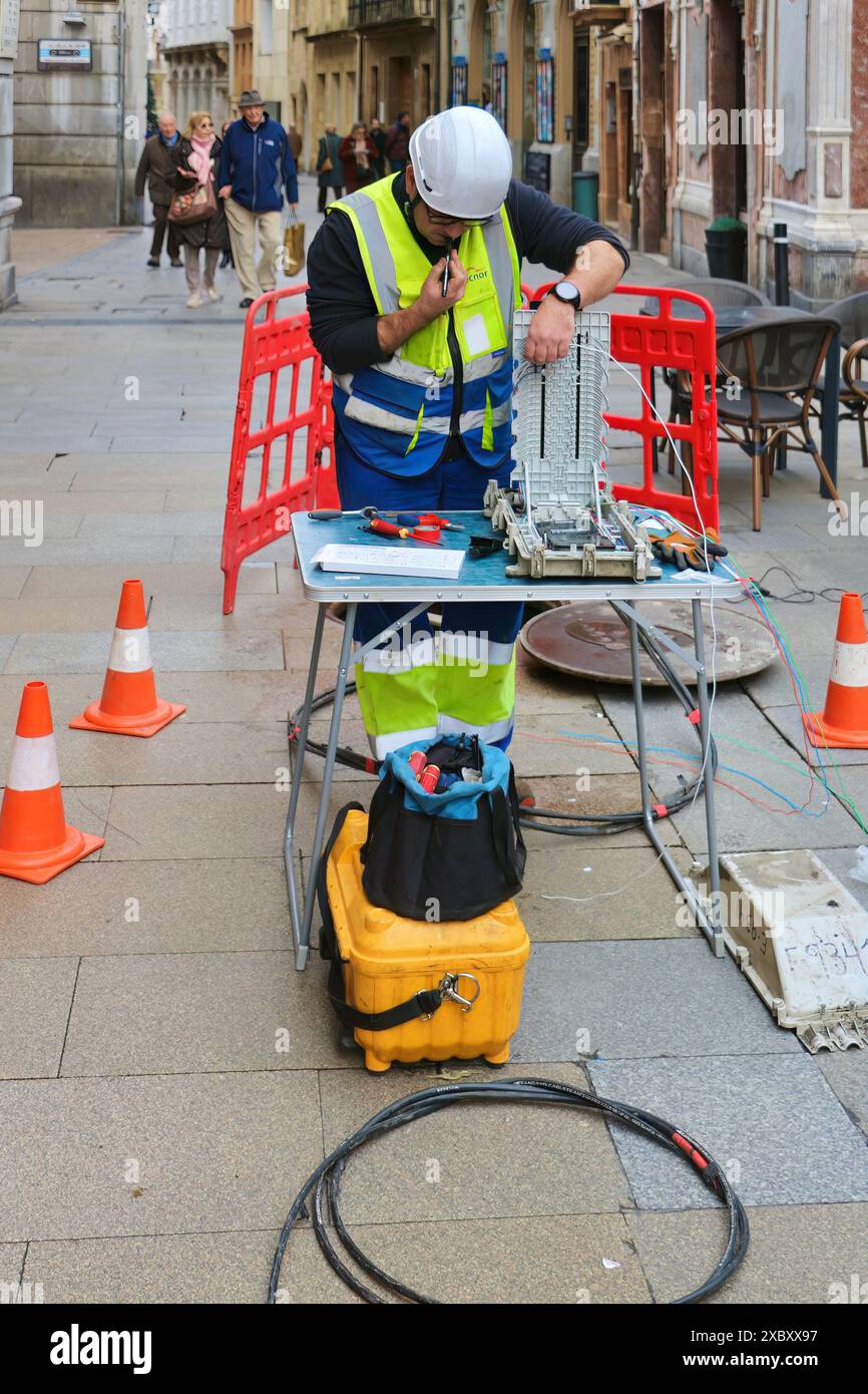 Ingegnere di telecomunicazioni che lavora con strumenti linee attrezzature e tavoli all'esterno nel centro storico pedonale di Oviedo Asturias, Spagna Foto Stock