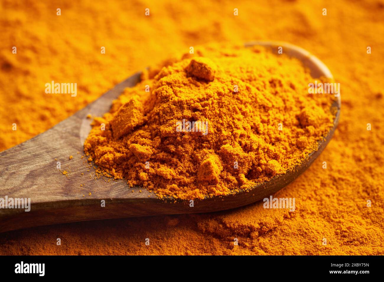 Polvere di radice di curcuma essiccata su un cucchiaio, primo piano Foto Stock