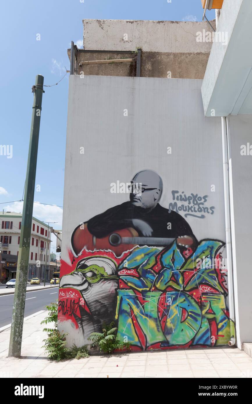 Graffiti con ritratto del musicista greco Giorgos Moukidis, con la chitarra, via Praeus, Atene, Grecia Foto Stock