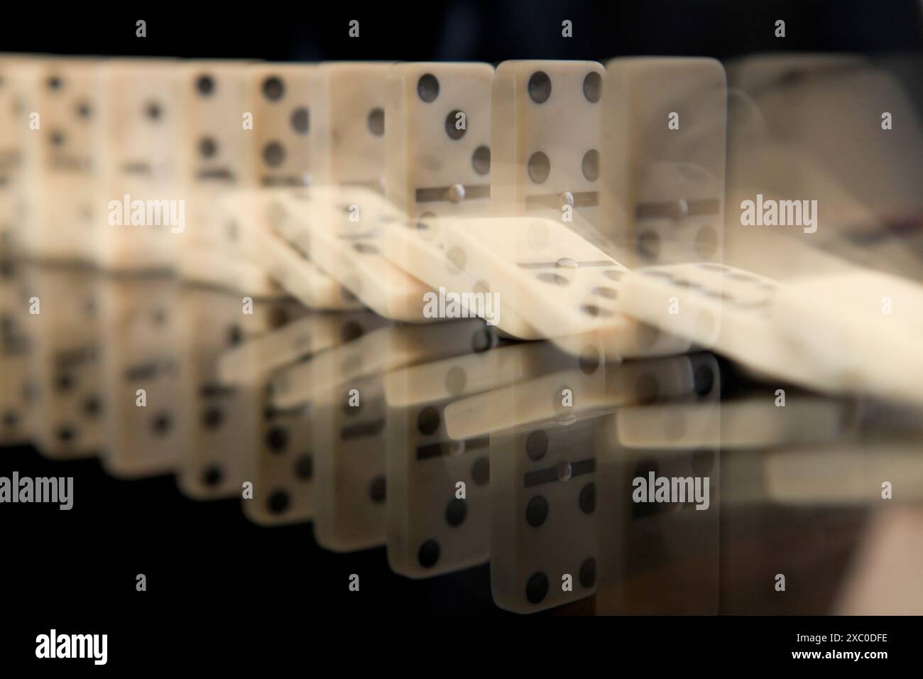 Domino che cadono di fila. Concetto di effetto domino Foto Stock