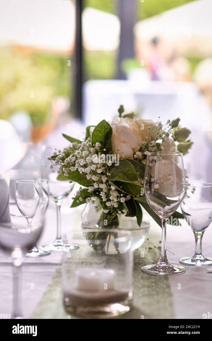 Tavolo da nozze con bicchieri da vino e mazzi di fiori Foto Stock