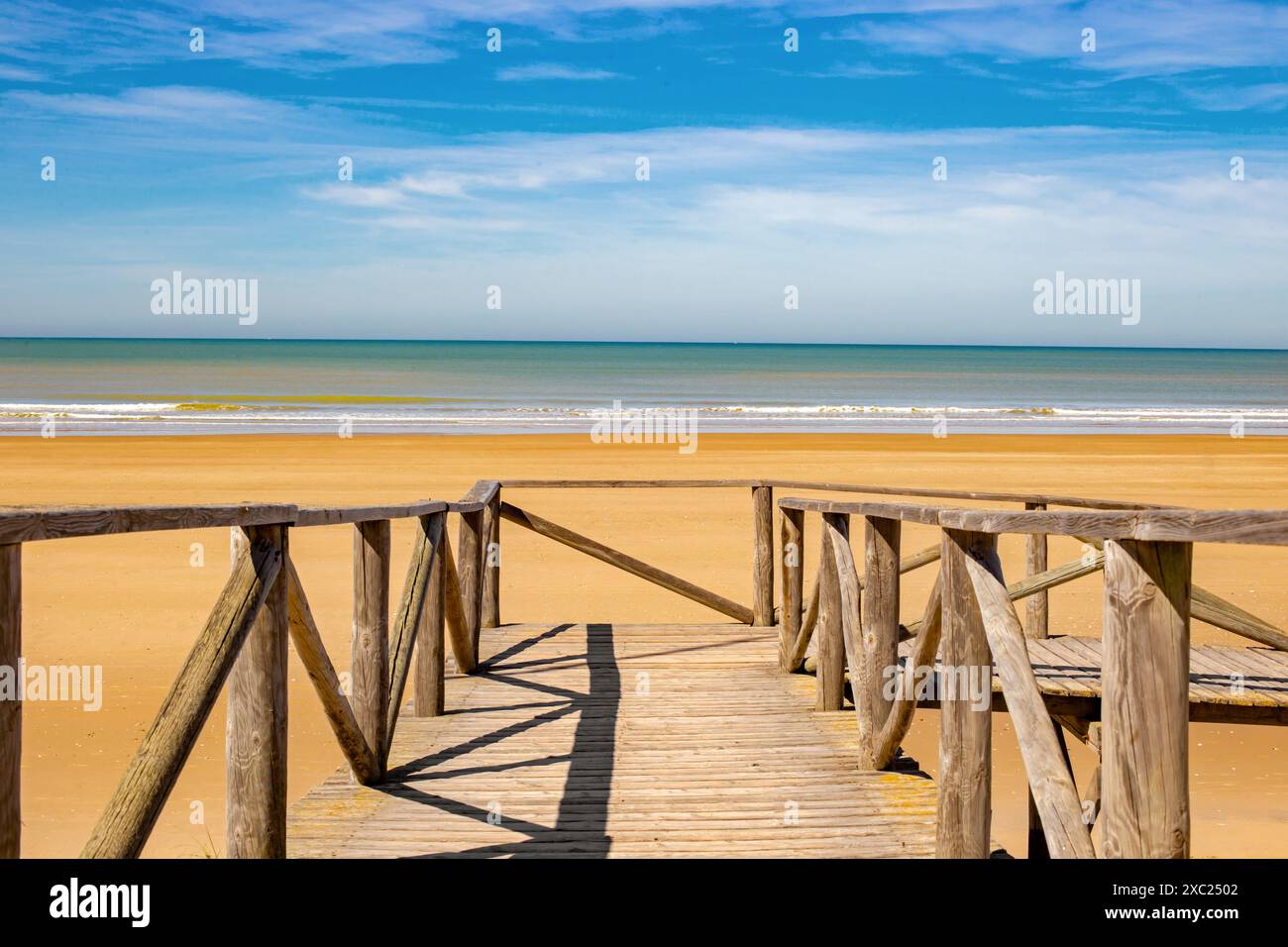 Vista di un sentiero in legno verso una spiaggia solitaria nel sud della Spagna in estate Foto Stock