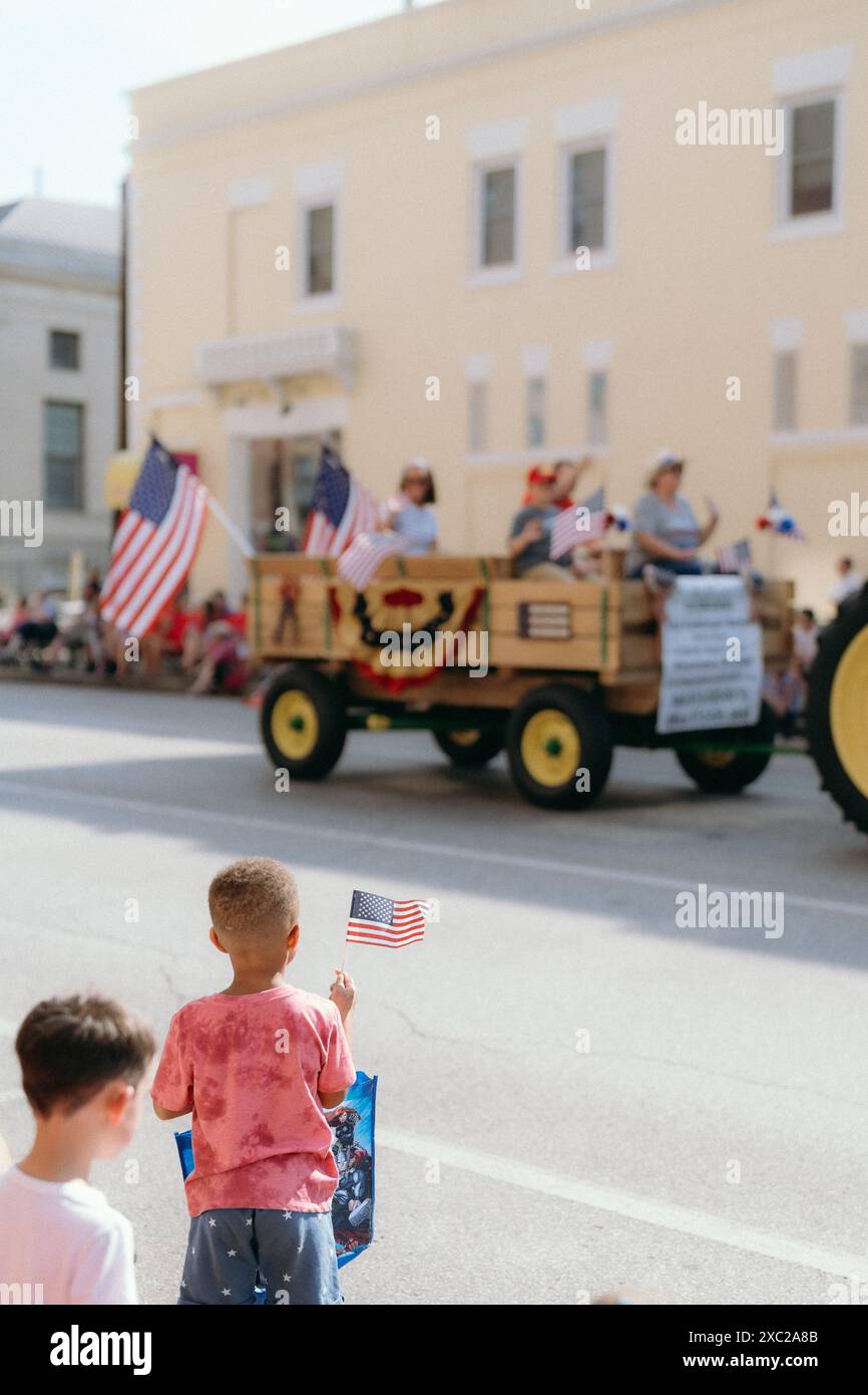 Bambini che sventolano bandiera americana durante la parata del 4 luglio Foto Stock