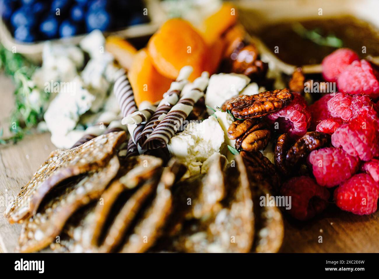 Tagliere artigianali di salumi con cioccolato, formaggio e frutti di bosco freschi Foto Stock