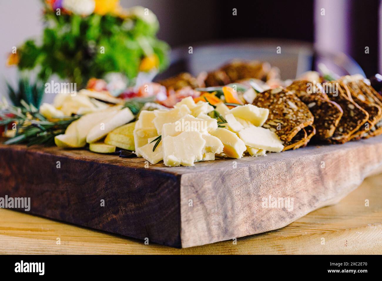 Squisito vassoio di formaggi con cracker ed erbe fresche Foto Stock