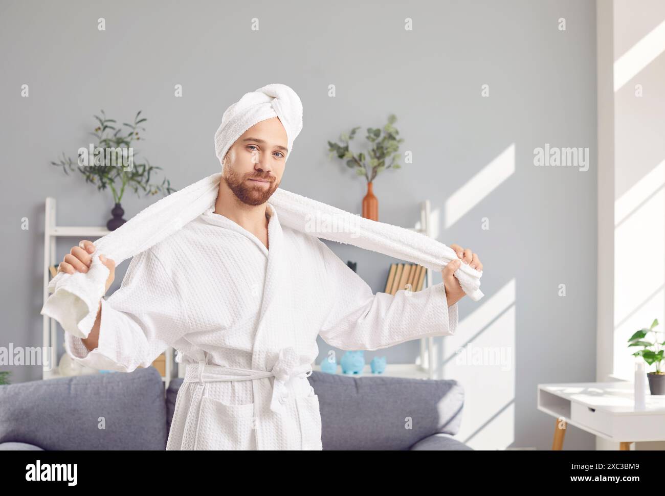Ritratto dell'uomo in accappatoio bianco e asciugamano dopo aver fatto la doccia e lavato i capelli Foto Stock