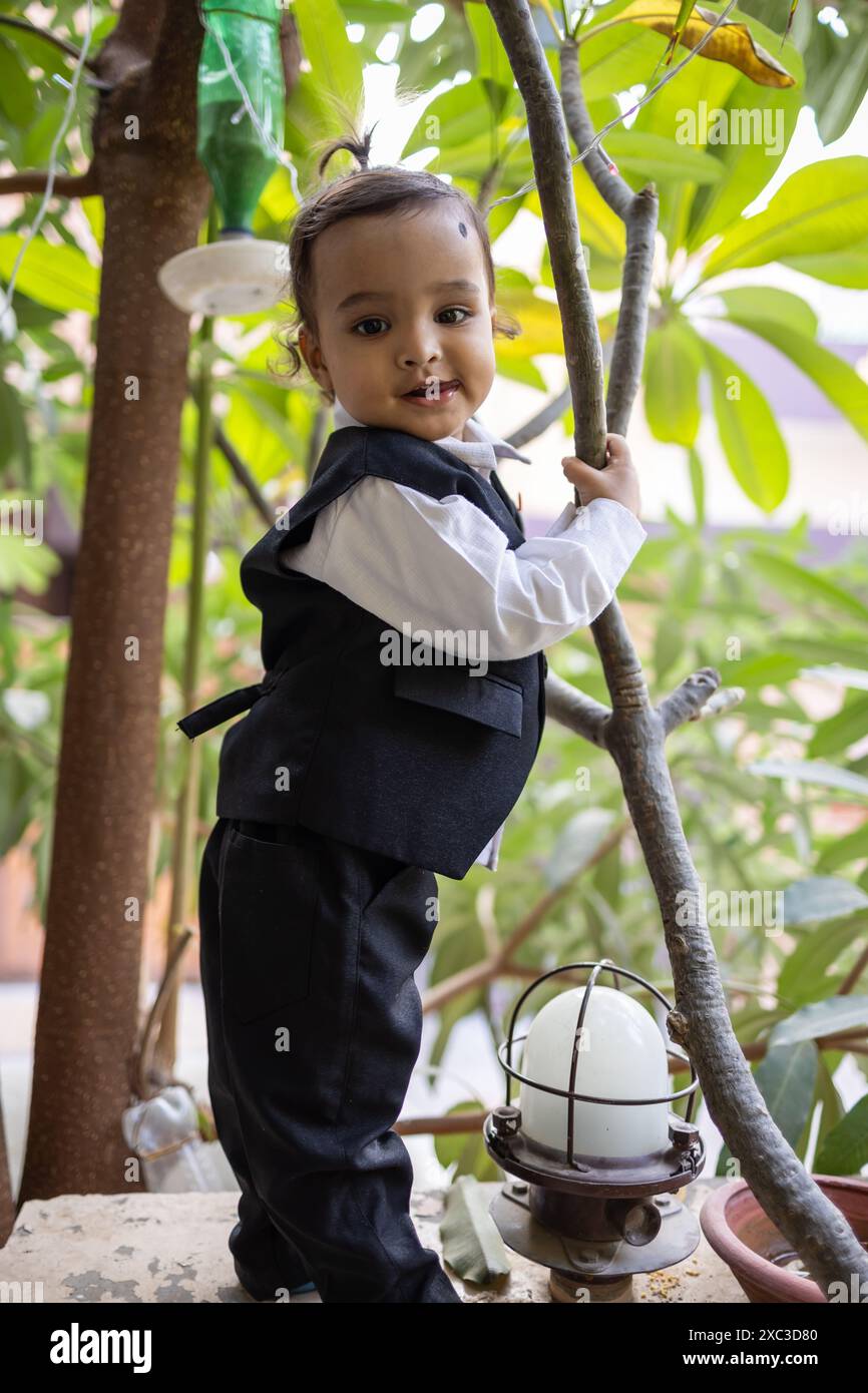 simpatico bambino indiano in tuta nera all'aperto da diverse angolazioni Foto Stock