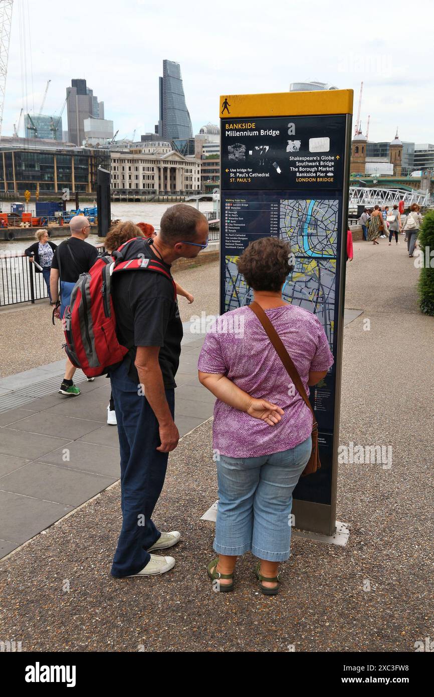 LONDRA, Regno Unito - 8 LUGLIO 2016: I turisti consultano il cartello pubblico della mappa di Bankside London, Regno Unito. Londra è la città più popolosa del Regno Unito con 13 milioni di peo Foto Stock