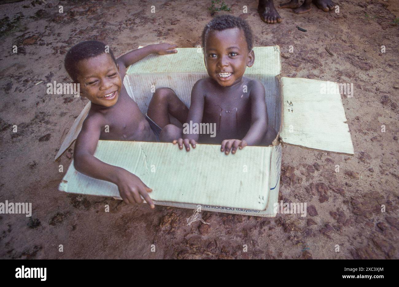 Suriname, Drietabbetje. I bambini Maroon giocano in una scatola vicino al confine con la Guinea francese. Foto Stock