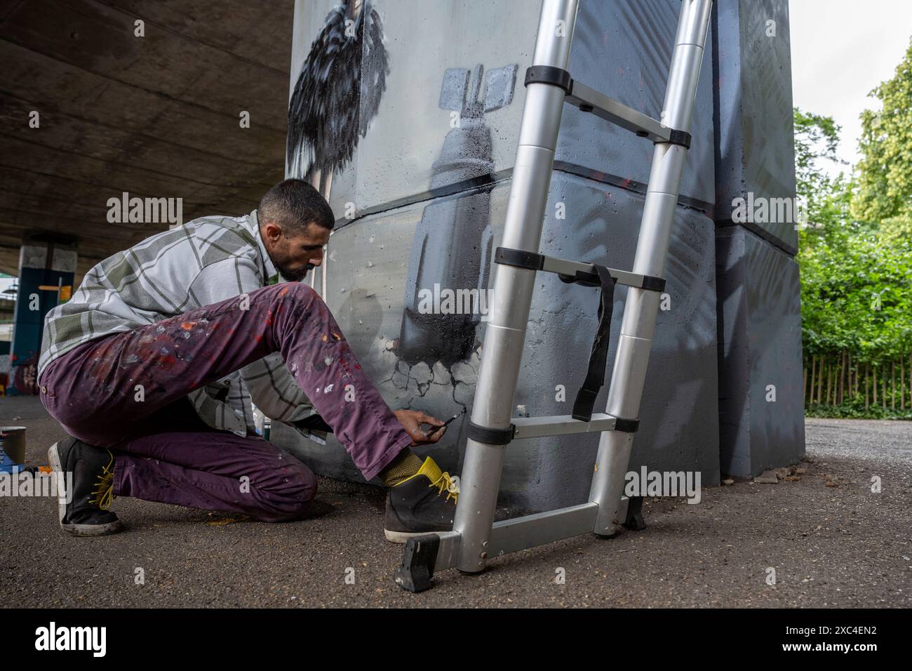 Londra, Regno Unito. 14 giugno 2024. [SOLO PER USO EDITORIALE] l'artista di strada Taqi Spateen dalla Palestina crea un murale in Latimer Road sotto il Westway. Il murale fa parte del progetto del Festival culturale di Betlemme, istituito nel 2020, che sostiene artisti della Palestina. Il signor Spateen è alla tappa finale di un tour nel Regno Unito che mostra la sua Street art e il tour terminerà a Belfast la prossima settimana. Crediti: Stephen Chung / Alamy Live News Foto Stock