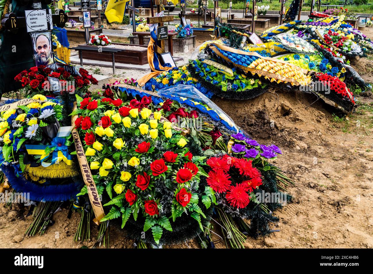 Charkiv, Ucraina, 13 giugno 2024 Aleya Slavy, cimitero militare a sud di Charkiv. Le tombe dei soldati, eroi che hanno difeso l'Ucraina sono coperte Foto Stock