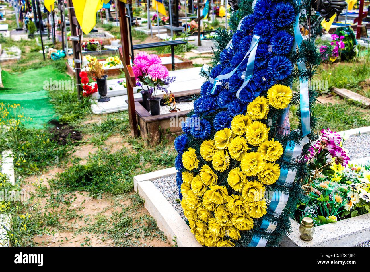 Charkiv, Ucraina, 13 giugno 2024 Aleya Slavy, cimitero militare a sud di Charkiv. Le tombe dei soldati, eroi che hanno difeso l'Ucraina sono coperte Foto Stock