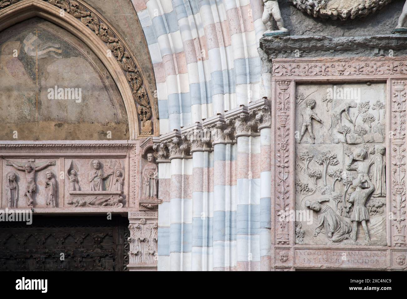 Piastrelle con il Martirio di San Pietro Martire in tarda gotica e primo Rinascimento portale del XV secolo sulla facciata della basilica gotica di Santa Anastasi Foto Stock