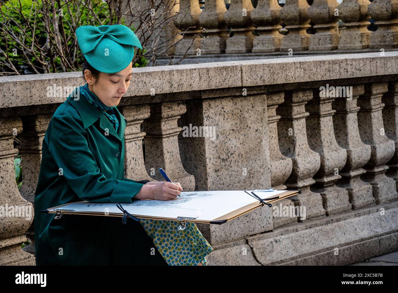 Artista donna asiatica alla moda, indossa un cappello, disegna su un grande pad. New York, New York, Stati Uniti Foto Stock