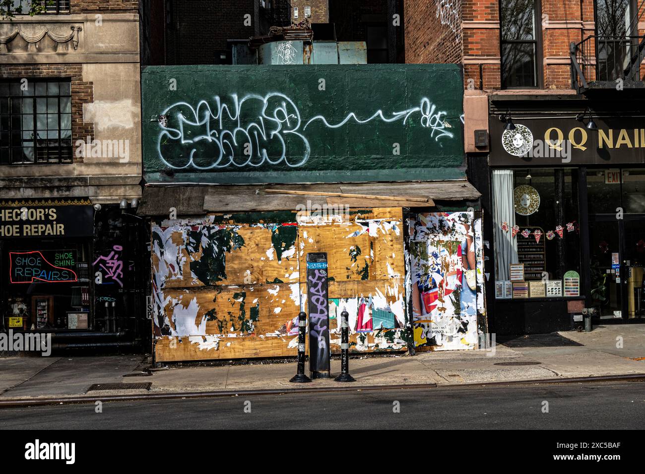 Negozio abbandonato su Greenwich Avenue coperto da poster strappati e graffiti a Greenwich Village, Manhattan, New York, New York, New York, Stati Uniti Foto Stock