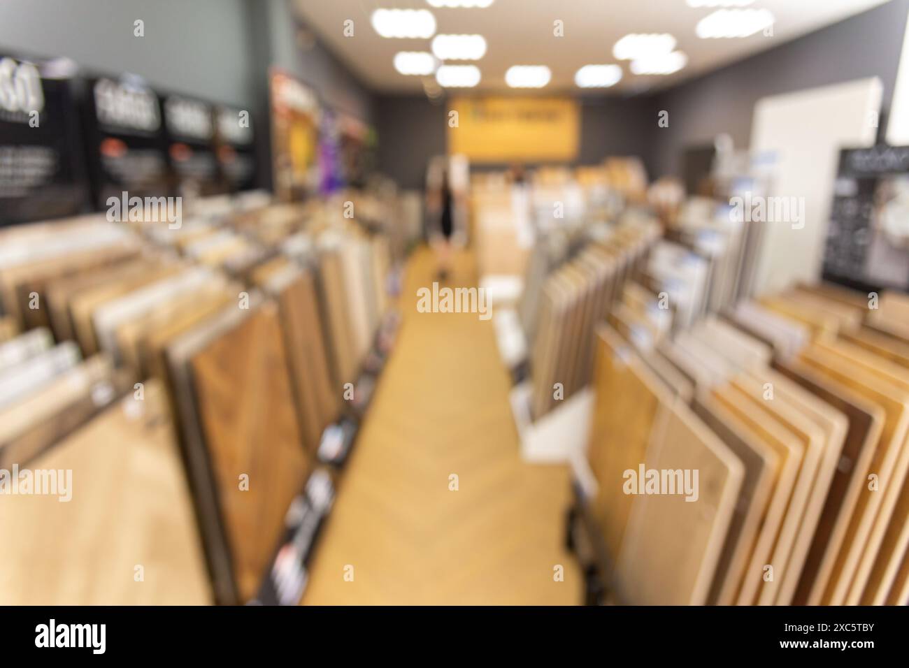 Immagine di sfondo sfocata dell'interno di un salone di vendita di rivestimenti per pavimenti. Assortimento di campioni di pavimenti laminati in ferramenta Foto Stock