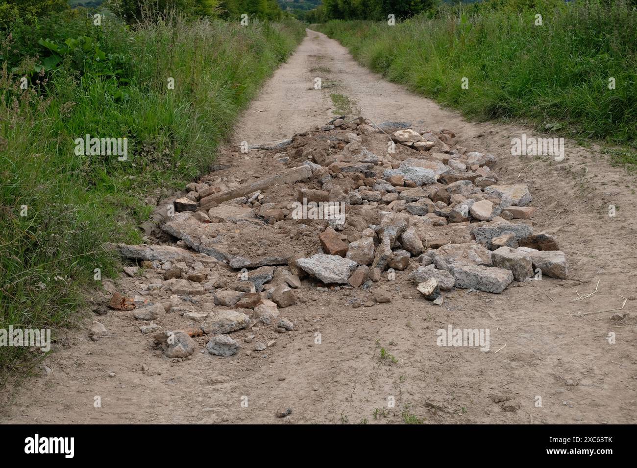 Giugno 2024 - le macerie e il calcestruzzo dei costruttori vengono utilizzati per riempire un terreno accidentato, possibile ribaltamento delle mosche. Foto Stock