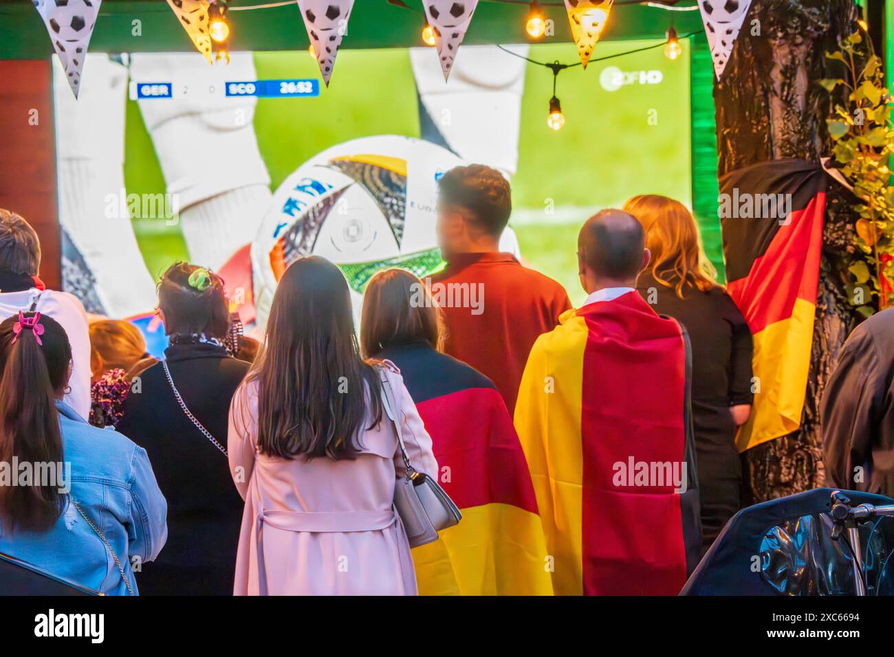 Public Viewing an der Leopoldstraße, Eröffnungsspiel Deutschland gegen Schottland, UEFA EURO 2024, München, 14. Juni 2024 Deutschland, München, 14. Juni 2024, deutsche Fußballfans beim Public Viewing an der Eröffnungsspiel beim Leopoldstraße Deutschland gegen Schottland, Endstand 5:1, hier in der ersten Halbzeit beim Stand von 2:0, Fußballfreunde mit Deutschlandfahnen bei der Live-Übertragung im Außenbereich einer Gastwirtschaft, die Fußball-Europameisterschaft dauert bis zum 14. Juli, Fußball, Sport, *** proiezione pubblica a Leopoldstraße, partita di apertura Germania contro Scozia, UEFA EURO 2024, Muni Foto Stock