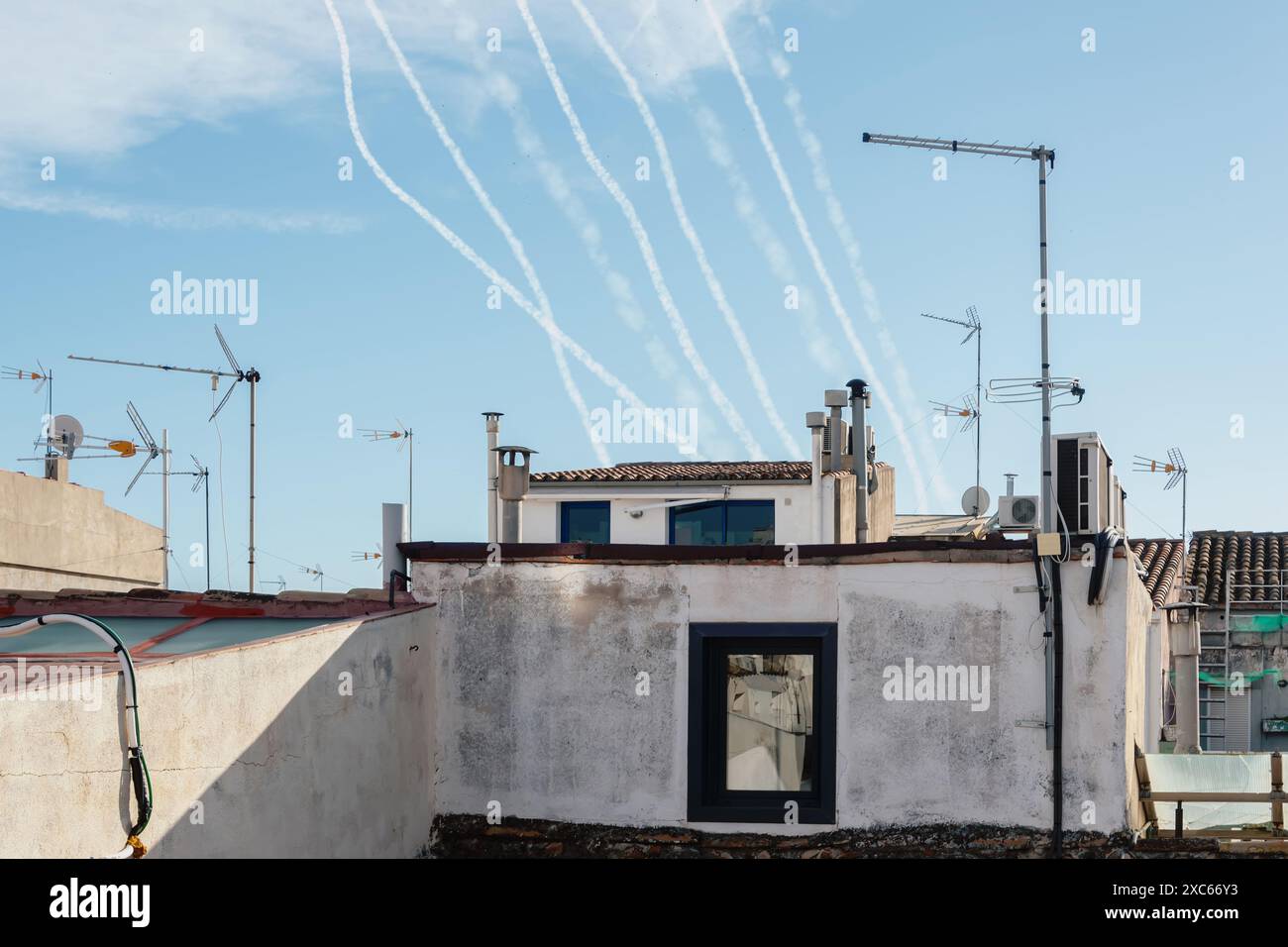 Pista di fumo da diversi missili militari sullo sfondo del cielo e delle case. Concetto: Attacco missilistico, allerta aerea, guerra in Medio Oriente, missile A. Foto Stock