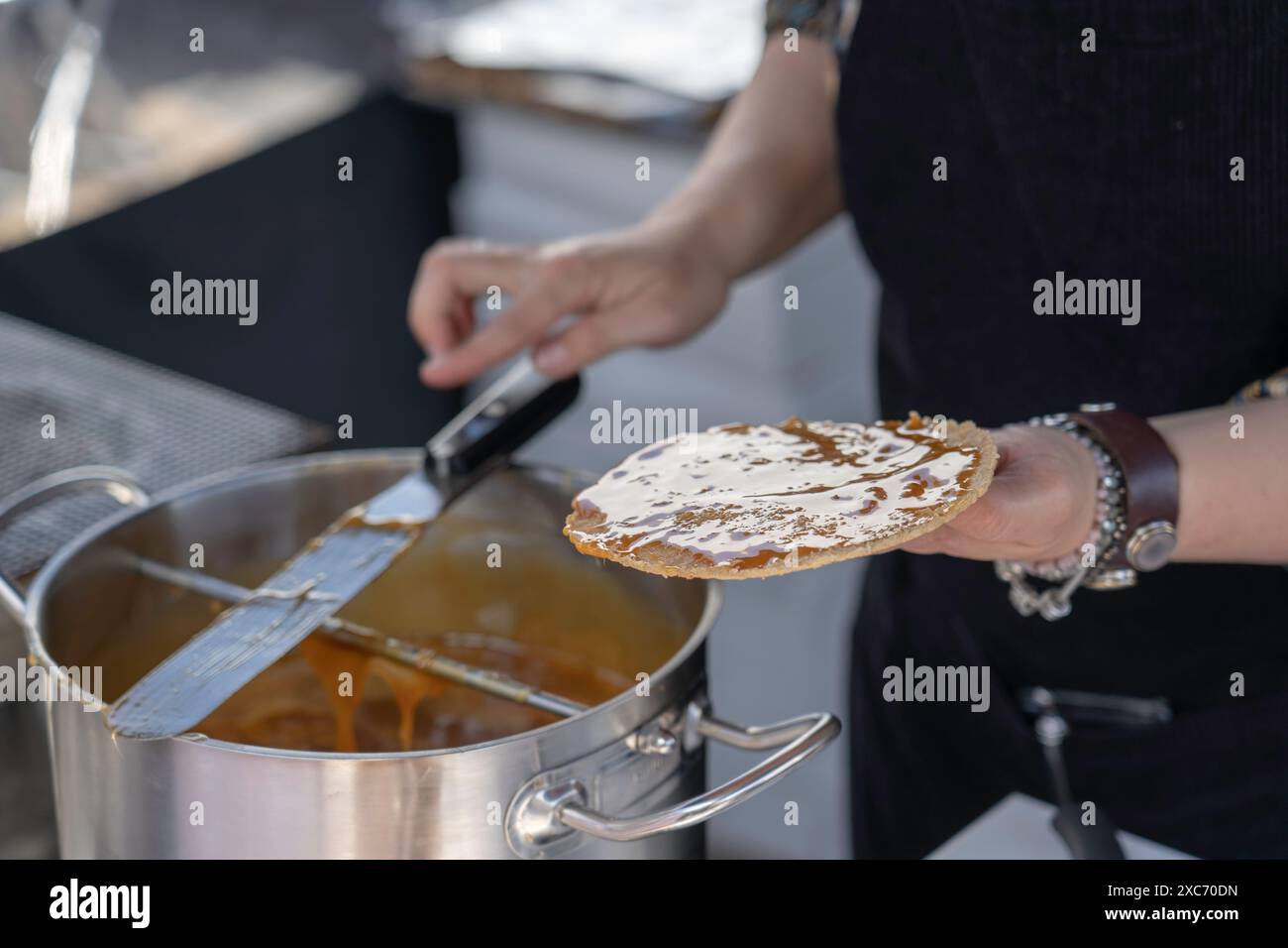 Persona nei mercati locali dei Paesi Bassi che prepara i waffle olandesi stroopwafel. Foto Stock