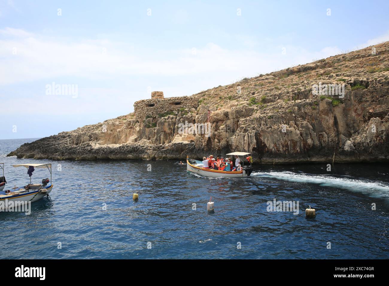 Qrendi, Malta. 14 giugno 2024. La gente prende una barca per la Grotta Azzurra a Qrendi, Malta, il 14 giugno 2024. La Grotta Azzurra, situata nella parte meridionale di Malta, è una delle attrazioni naturali più popolari di Malta. Crediti: Chen Wenxian/Xinhua/Alamy Live News Foto Stock