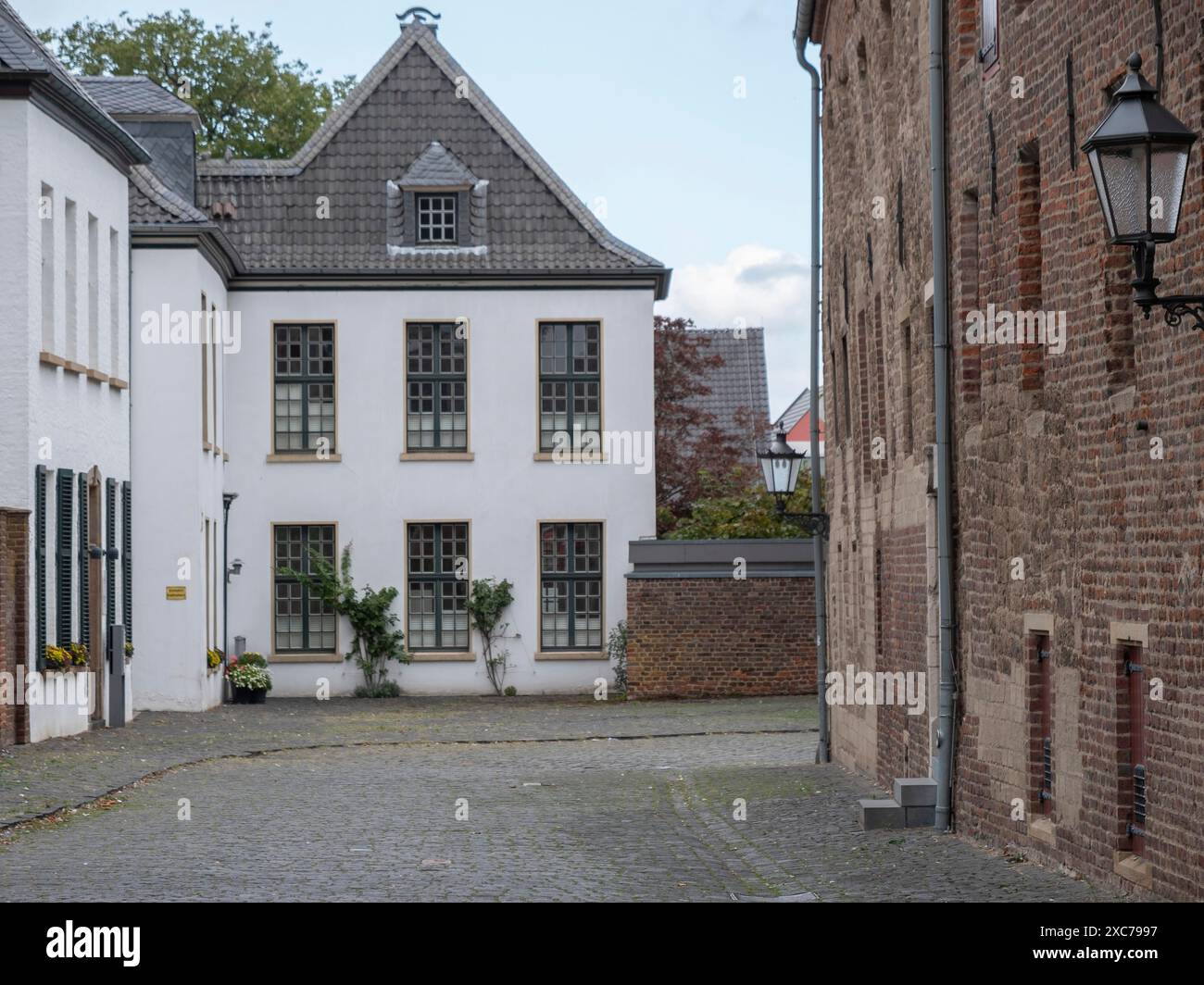 Vicolo tranquillo con case bianche e in mattoni e tradizionali finestre a lanterna, Xanten, Renania settentrionale-Vestfalia, Germania Foto Stock