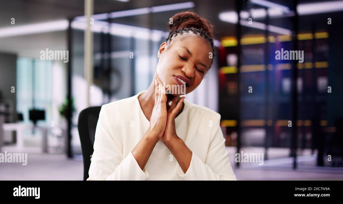 Trattamento del cancro della gola faringea: Una donna afroamericana che usa il computer per alleviare il dolore laringeo in clinica isolata Foto Stock