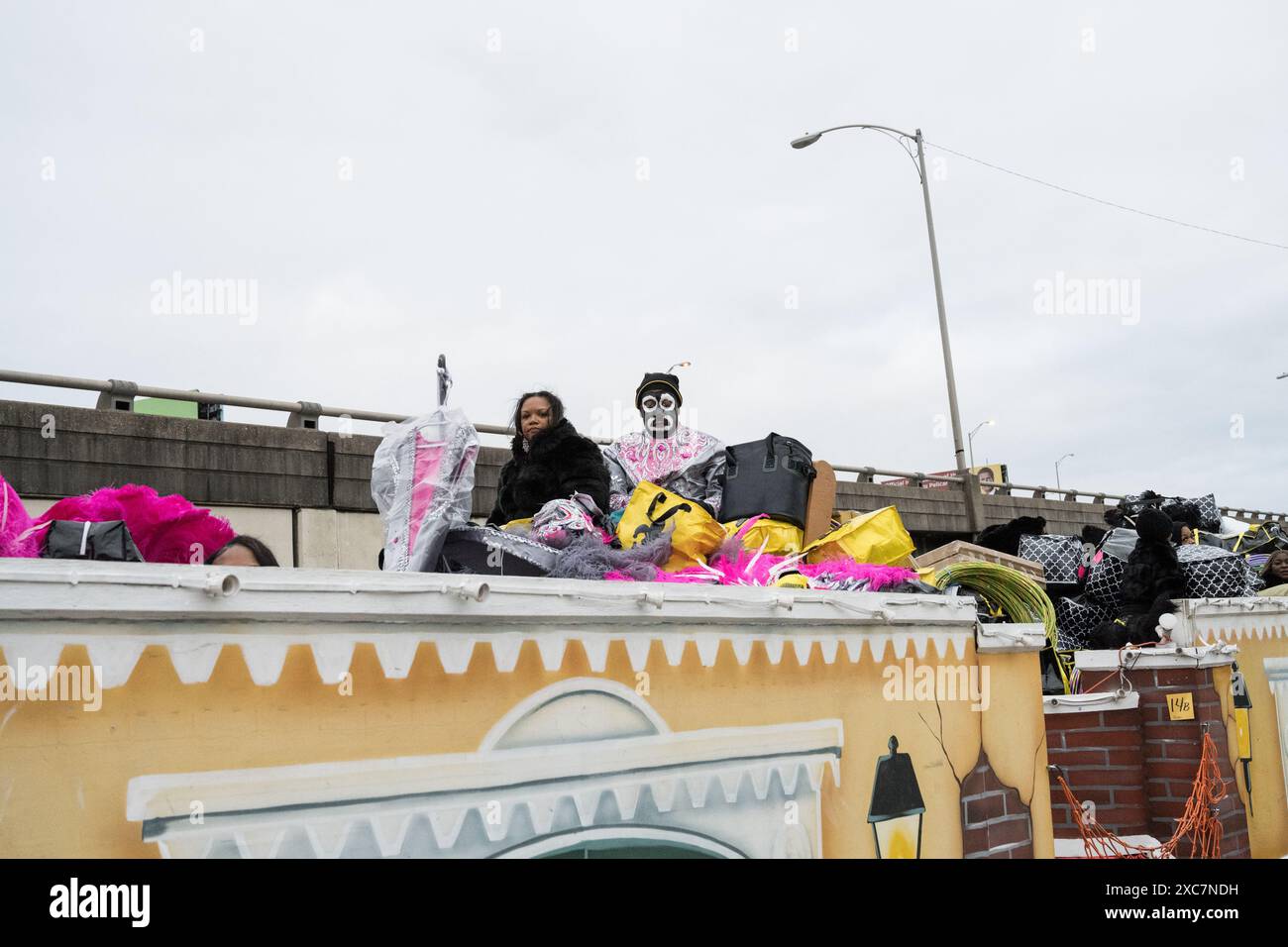 I membri Zulu krewe in elaborati costumi di piume e vernice per il viso si riuniscono fuori da un negozio, preparandosi per la parata annuale del Mardi Gras a New Orleans. Foto Stock