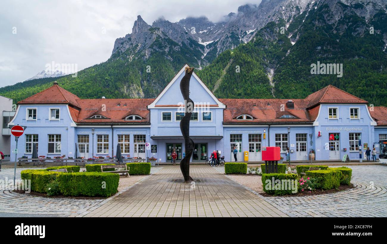 Die Marktgemeinde Mittenwald mit historischen Gebäuden Mittenwald liegt im Landkreis Garmisch-Partenkirchen, ist Deutschlands höchstgelegener Luftkurort und berühmt wegen der traditionellen Kunst des Geigenbaus. In der historischen Altstadt sind viele Häuser auf der Fassade mit kunstvoller Lüftlmalerei geschmückt. Im Bild der Bahnhof von Mittenwald, dahinter das Karwendelgebirge Mittenwald Bayern Deutschland *** la città mercato di Mittenwald con edifici storici Mittenwald si trova nel quartiere di Garmisch Partenkirchen, è la più alta località climatica della Germania ed è famosa per il Foto Stock