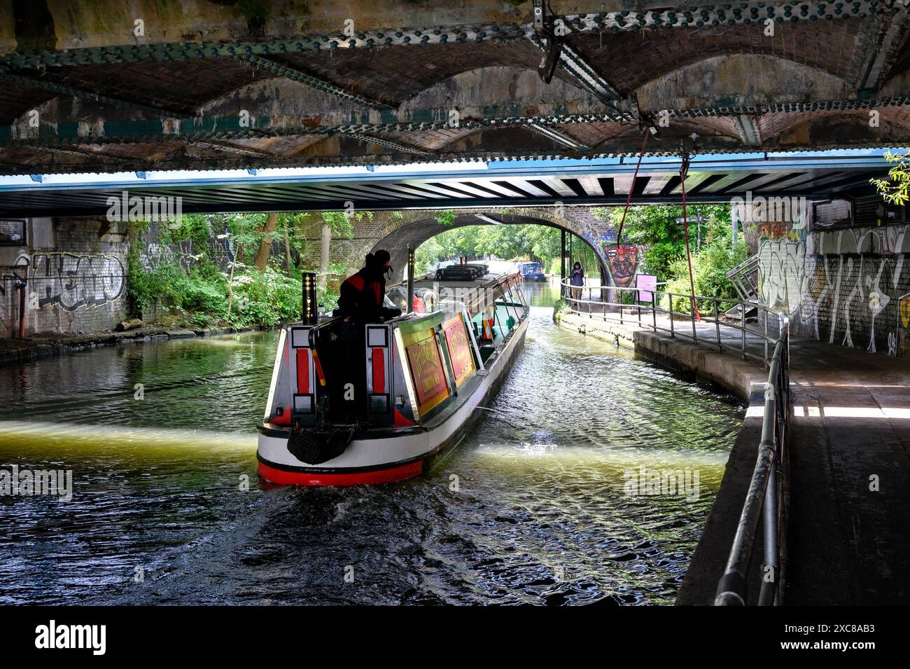Londra, Regno Unito. Chiatta che passa sotto un ponte vicino a Camden Lock sul Regents Canal. Foto Stock