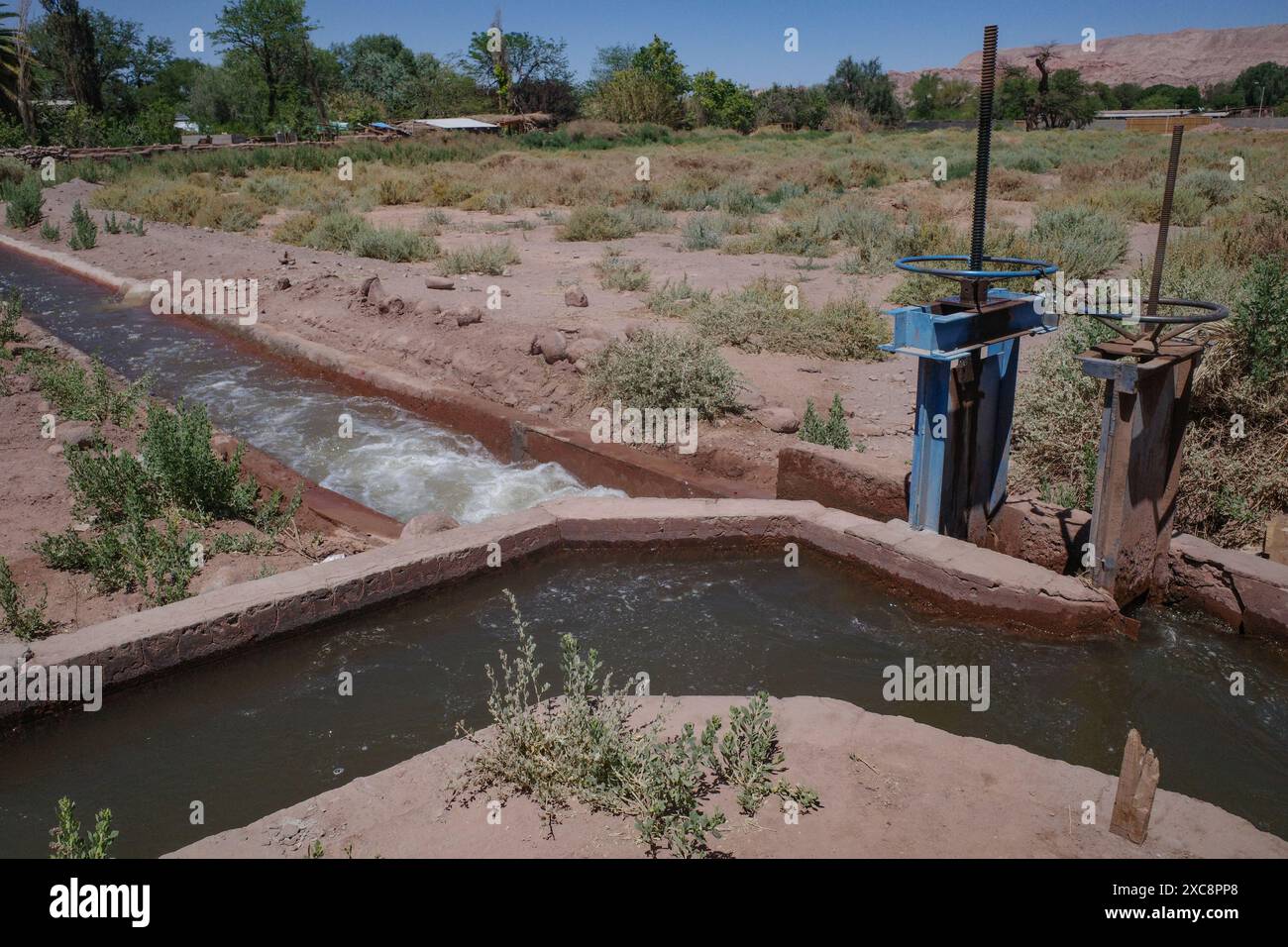 San Pedro de Atacama, Cile - canali di irrigazione e pompe che trasportano acqua attraverso terreni agricoli nel deserto di Atacama Foto Stock