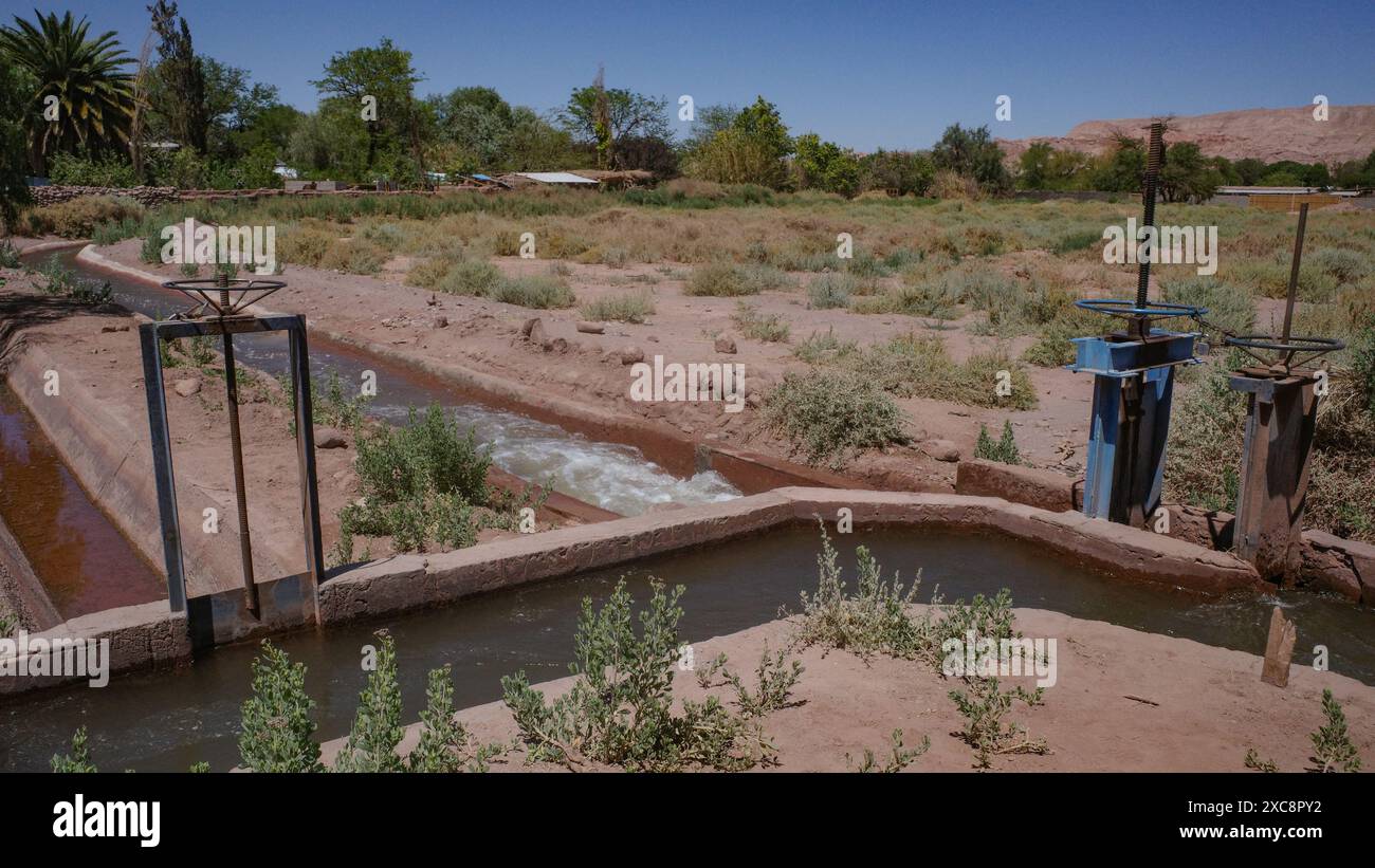 San Pedro de Atacama, Cile - canali di irrigazione e pompe che trasportano acqua attraverso terreni agricoli nel deserto di Atacama Foto Stock