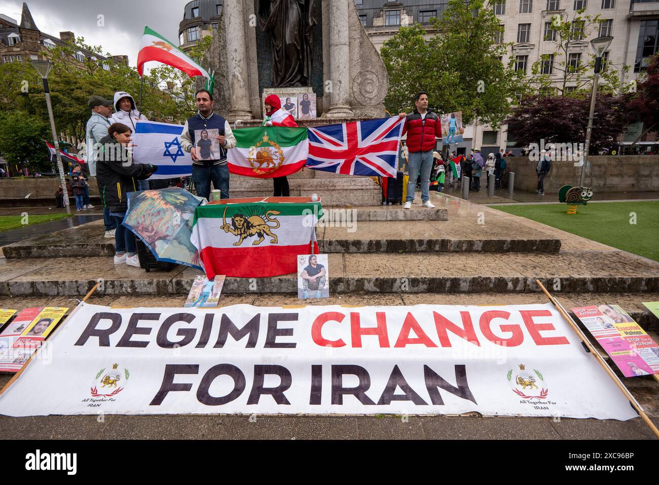 Manchester, Regno Unito. 15 giugno 2024. Il cambio di regime per i manifestanti iraniani protestano contro le proteste di guerra in Palestina a Gaza a Manchester nel Regno Unito durante le forti piogge. I manifestanti hanno marciato da Piazza San Pietro attraverso il centro della città. Gli striscioni includevano messaggi che chiedevano a Israele di liberare i prigionieri politici palestinesi e criticavano la Barclays Bank. Crediti: GaryRobertsphotography/Alamy Live News Foto Stock