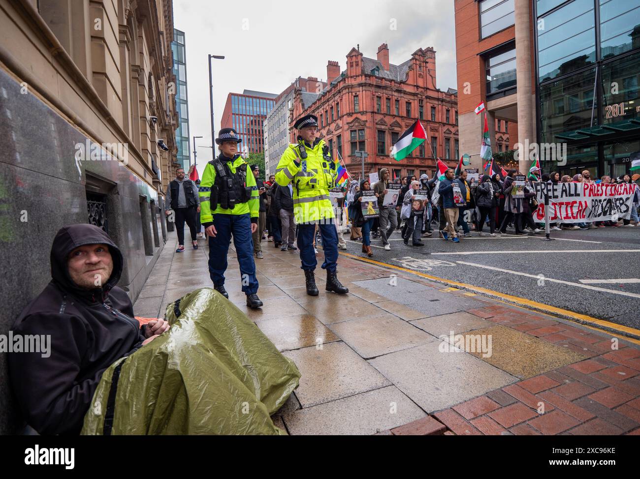 Manchester, Regno Unito. 15 giugno 2024. Un senzatetto attende l'arrivo delle proteste di guerra di Gaza in Palestina a Manchester nel Regno Unito durante le forti piogge. I manifestanti hanno marciato da Piazza San Pietro attraverso il centro della città. Gli striscioni includevano messaggi che chiedevano a Israele di liberare i prigionieri politici palestinesi e criticavano la Barclays Bank. Crediti: GaryRobertsphotography/Alamy Live News Foto Stock