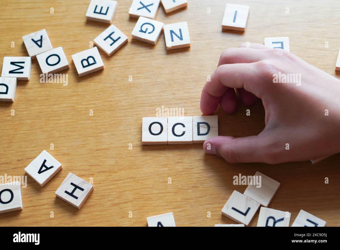 Mano che posiziona le lettere OCD disturbo ossessivo compulsivo Foto Stock