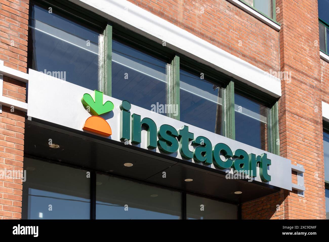 Primo piano del cartello con il logo Instacart sull'edificio. Liberty Village, Toronto, Canada, il 17 ottobre 2023. Foto Stock