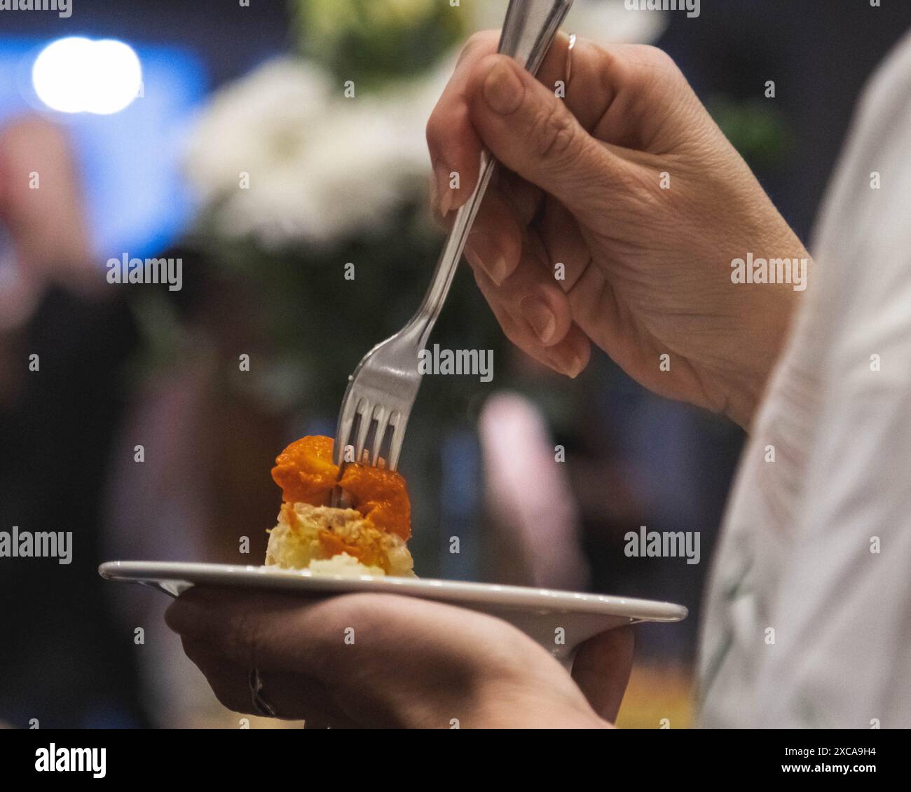 le mani di una persona che si diverte a mangiare ad un evento sociale Foto Stock