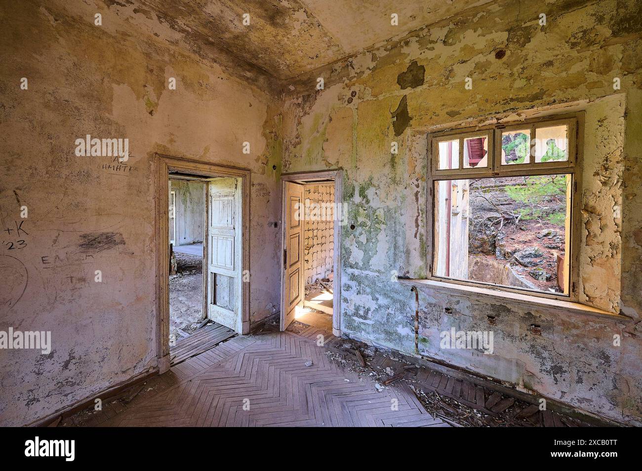 Camera fatiscente con pareti sporche, una finestra aperta e una porta aperta, con muffa verde e interni fatiscenti, Villa Mussolini, Villa de vecchi Foto Stock