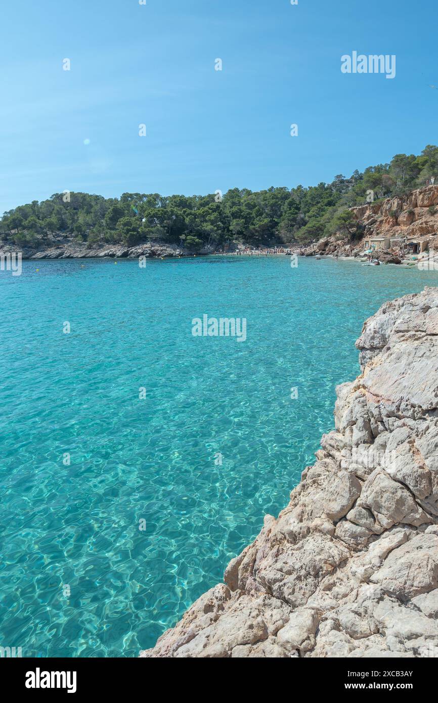 Acque turchesi di Cala Saladeta a Ibiza in estate. Foto Stock