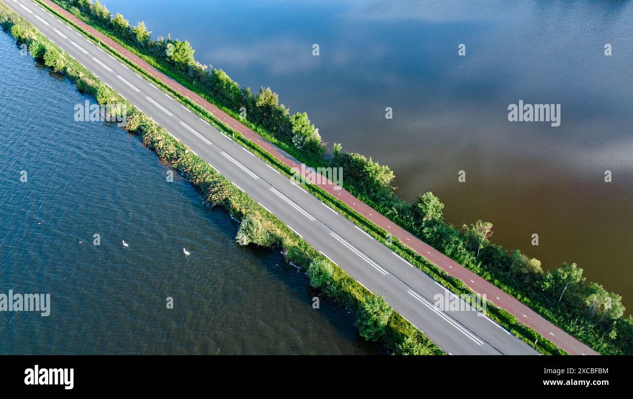 Vista aerea con droni della strada autostradale e pista ciclabile sulla diga polder, traffico auto dall'alto, Olanda settentrionale, Paesi Bassi Foto Stock