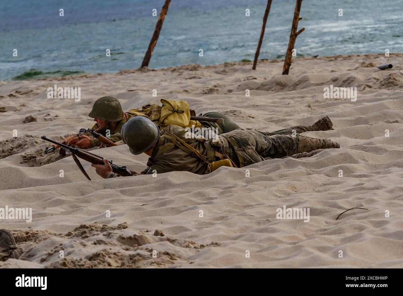 Soldati americani che combattono sulla spiaggia durante la ricostruzione della storica battaglia contro la seconda guerra mondiale. Foto Stock