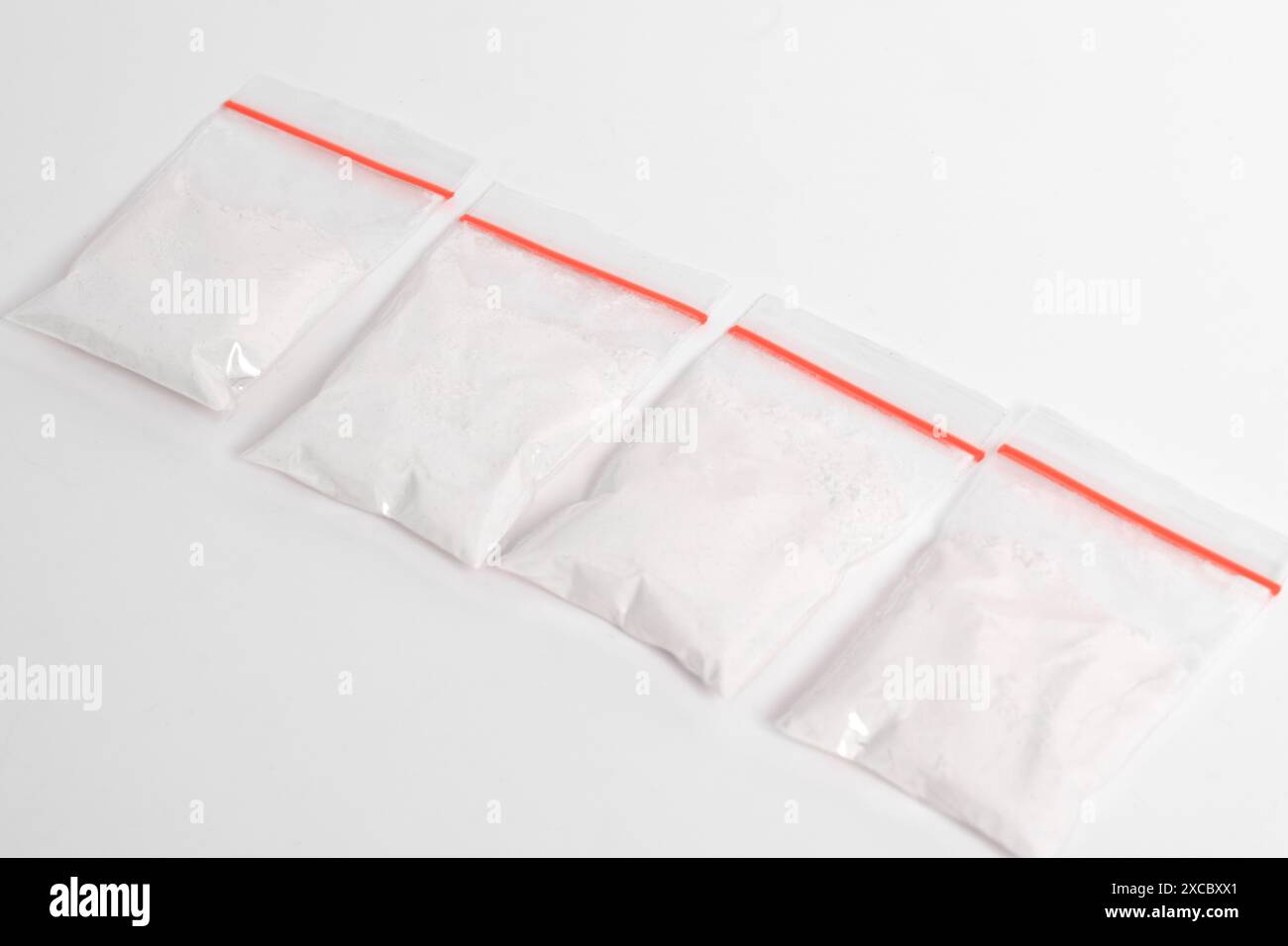 Cocaina in confezione di plastica isolata su sfondo bianco. illustrazione di sostanze illegali, polvere bianca, narcotici Foto Stock