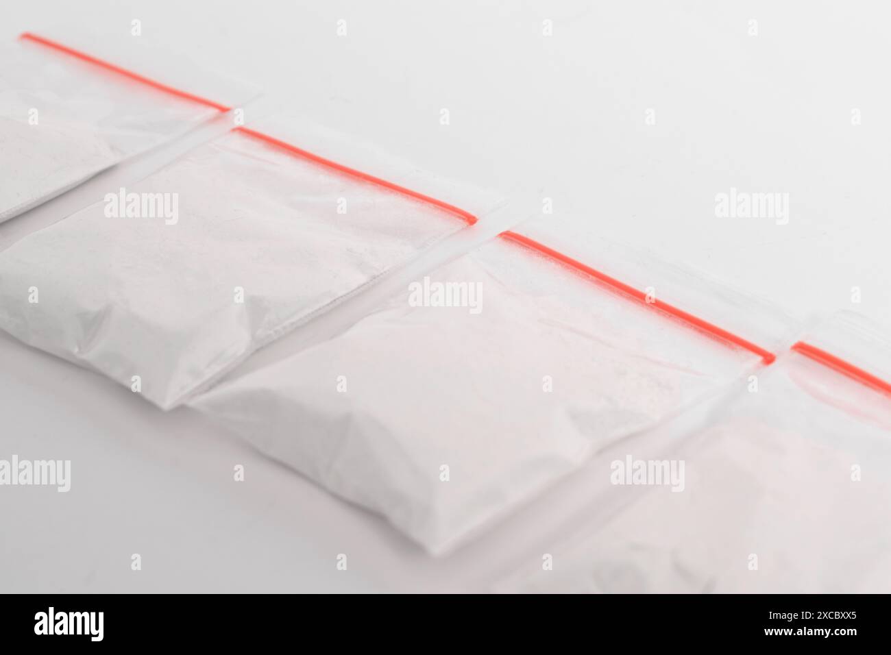 Cocaina in confezione di plastica isolata su sfondo bianco. illustrazione di sostanze illegali, polvere bianca, narcotici Foto Stock