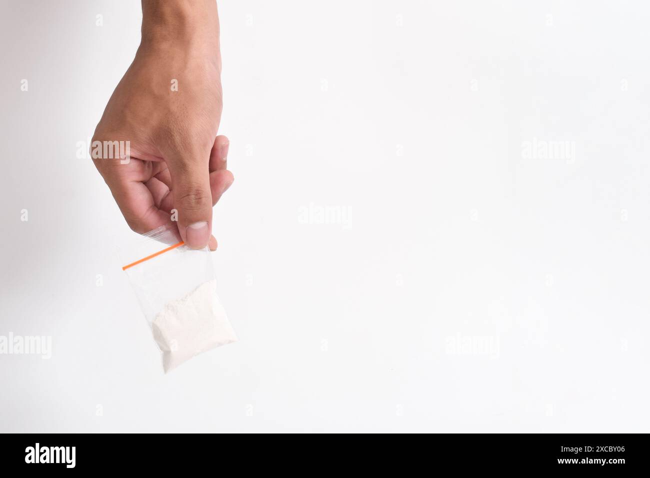 La mano fornisce cocaina in un contenitore di plastica isolato su sfondo bianco. Illustrazione di sostanze stupefacenti illegali, narcotici Foto Stock
