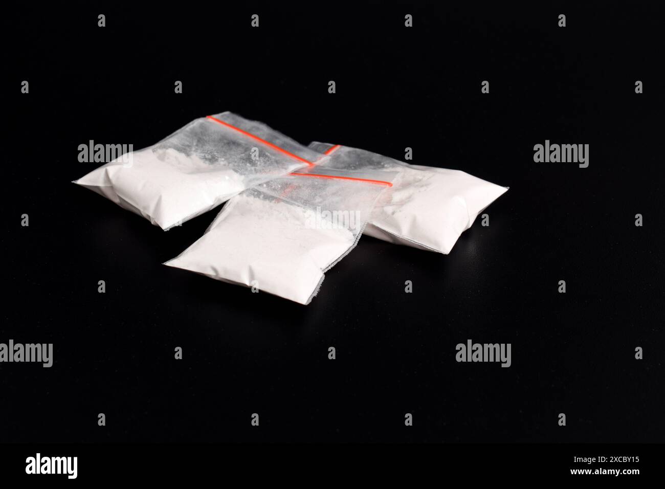 Cocaina in confezione di plastica isolata su sfondo nero. illustrazione di sostanze stupefacenti illegali, narcotici Foto Stock